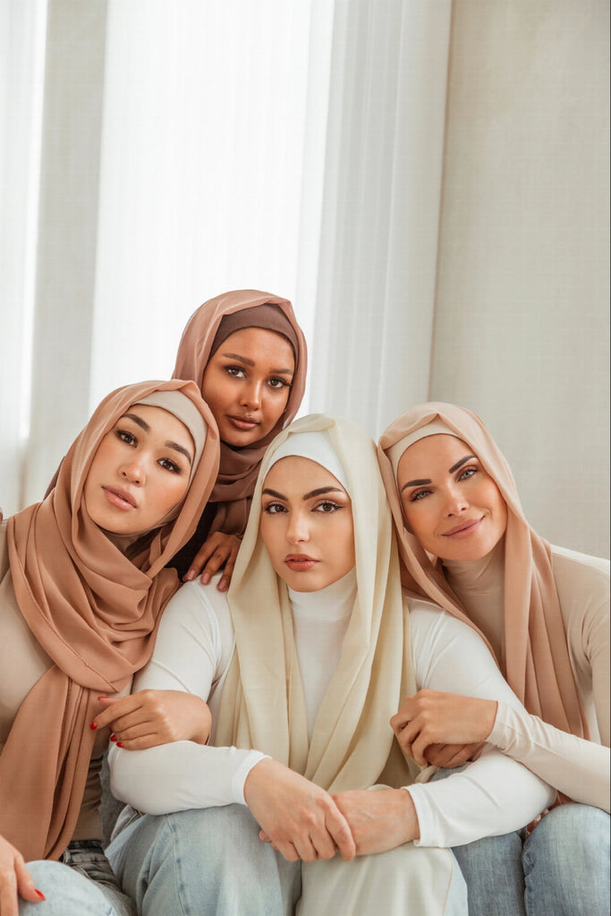 Four women wearing hijab / scarf over ruuq hijab bodysuits.