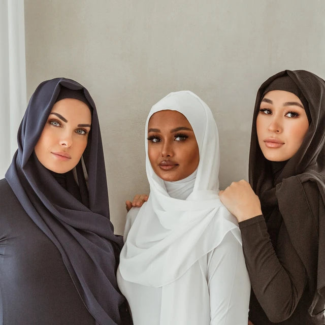 Three women of different racial backgrounds wearing hijab supporting each other for Black History month.