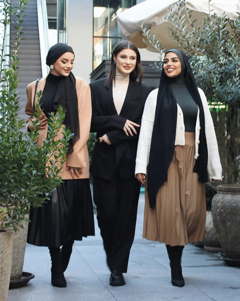 3 women walking outdoors in a mix of modern and traditional clothing styles and hijab bodysuit 